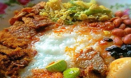 Makanan khas bubur Suro merupakan makanan yang memiliki makna tersendiri bagi masyarakat Indonesia dalam menyambut datangnya tahun baru Islam. Bubur suro sering disajikan setiap tanggal 1 Suro atau 1 Muharram. Peringatan ini dilakukan oleh masyarakat Jawa yang secara turun temurun bahkan berabad-abad. Sayangnya, makanan khas yang satu ini sudah banyak ditinggalkan dan hanya dilakukan oleh para sesepuh demi mempertahankan tradisi budaya. Sponsor: Makna dibalik sajian bubur Suro: Bubur Suro bukan hanya sebuat budaya tradisi tetapi juga mengandung makna atau filosofi. Tak hanya itu, sama seperti tradisi atau budaya lain dimana elemen kuliner menjadi perlambang setiap lintas ritual. Misalnya, setiap hari raya Idul Fitri banyak kamu muslim Jawa yang menyiapkan nasi kuning atau sajian ketupat. Ada lai etnis Tionghoa yang menyajikan kue keranjang sebagai perlambang perayaan penting. Bagi masyarakat Jawa, bubur Suro menjadi salah satu dari sekian tradisi yang tak terpisahkan, dimana tradisi ini memberi warna juga nuansa sarat ritual agama. Bubur Suro juga mengandung makna rasa syukur, pesta atau sambut perayaan. Dimana bubur Suro sering disajikan pada malam menjelang datangnya 1 Muharram. Kadang kala bubur Suro juga disajikan pada saat esok hari di tahun baru Muharram. Perlu diingat bahwa kuliner bubur Suro yang disajikan bukanlan sebuah sesajen. Melainkan syarat dengan perlambang yang mana masyarakat islam Jawa harus bisa membaca, melihat atau mencerna hari serta memaknai arti datangnya tahun baru. Cara Membuat Bubur Suro yang lezat: Resep membuat bubur suro yang lezat adalah bagian yang mudah dan sederhana. Tak butuh bahan baku yang banyak untuk bisa membuat bubur ini. Bahan-bahan yang harus disajikan yakni berupa beras, santan, jahe, garam dan sereh. Setelah semua bahan siap, maka proses pengolahan bubur suro. Pertama siapkan panci untuk merebus. Masukkan beras beserta santan dan rebus hingga mendidih dan tambahkan daun salam, serai dan garam. Aduk hingga rata hingga bubur menjadi lembek dan kental. Angkat bubur yang telah matang lalu sajikan bersama dengan taburan. Setelah bubur selesai diolah, biasanya bubur akan ditaburi buah delima, jutuh jenis kacang seperti mete, kacang tanah, kacang hijau, kacang merah, tolo, kedelai, dan kacang bogor. Terakhir, bubur akan dipemanis dengan irisan mentimun dan daun kemangi. Soal rasa, bubur Suro terbilang enak dan gurih dengan nuansa asin serta pedas tipis. Jika ditambah dengan aneka taburan kacang, maka tekstur yang didapat adalah kremes dan kriuk. Selain itu, untuk menemani sajian lezat bubur Suro, lauk ditambahkan seperti opor atau sambal goreng. Campuran bubur ini diyakini sangat bergizi. Seperti yang diungkap kajian ilmiah oleh Universitas Atma Jaya, Jakarta dan Universitas Airlangga, Surabaya. Demikian ulasan mengenai salah satu kuliner khas menyambut tahun baru Islam di Jawa. Bubur Suro memiliki makna dan filosofi sebagai rasa sukur. Tak hanya itu, bubur Suro juga kaya gizi dan lezat. Semoga bubur Suro bisa memberi makna tersendiri dan keberadaannya bisa lestari sebagai salah satu bagaian dari tradisi dan budaya Indonesia